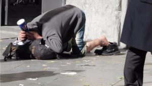 Un indigente pide ayuda en la calle