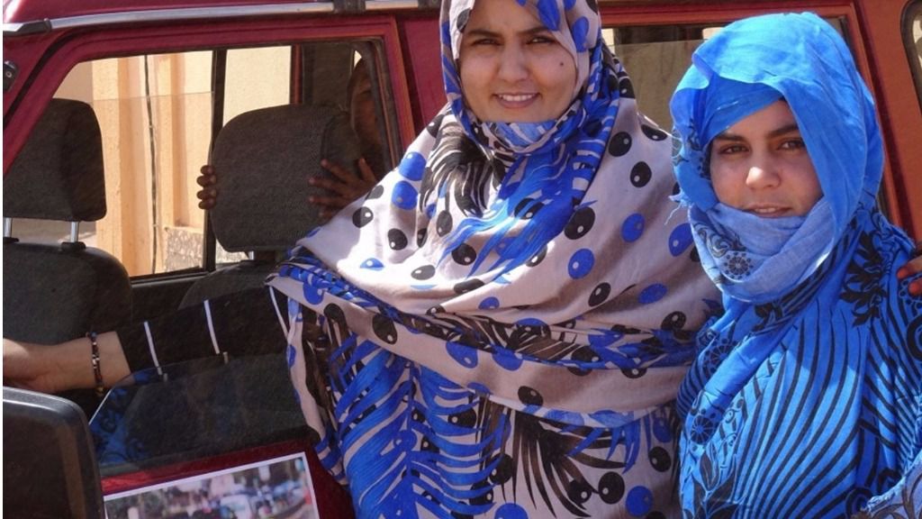 Las dos jóvenes posan orgullosas con uno de sus coches