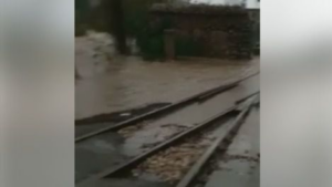 El agua del torrente invade la v&iacute;a del tren