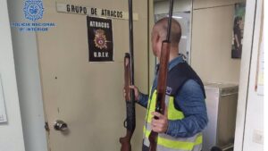 Un polic&iacute;a nacional sostiene dos de las armas intervenidas en un domicilio, tras la detenci&oacute;n de un hombre que dispar&oacute; al aire en La Soledat Nord