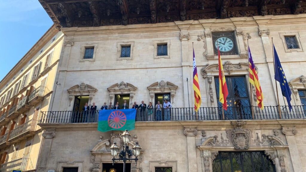 Representantes municipales y del colectivo gitano en Palma, durante el acto de colocación de la bandera del colectivo en el balcón de Cort