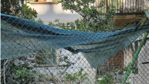 Valla del cuartel forzada. Al fondo edificio de oficiales okupado