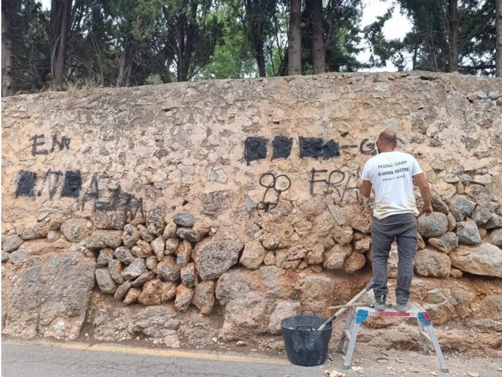 Unos operarios eliminan una pintada vandálica en Alaró