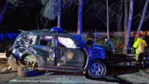 Uno de los coches de la Guardia Civil tras el accidente.