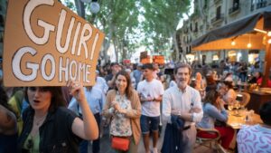 Manifestante antiturista con un cartel animando a los "guiris" a marcharse a su casa.