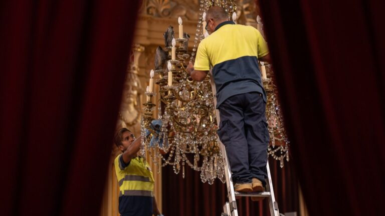 Operarios limpian las arañas de la Sala de las Cariátides.