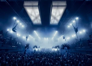 Multitud en una fiesta en Ibiza con luces y acrobacias