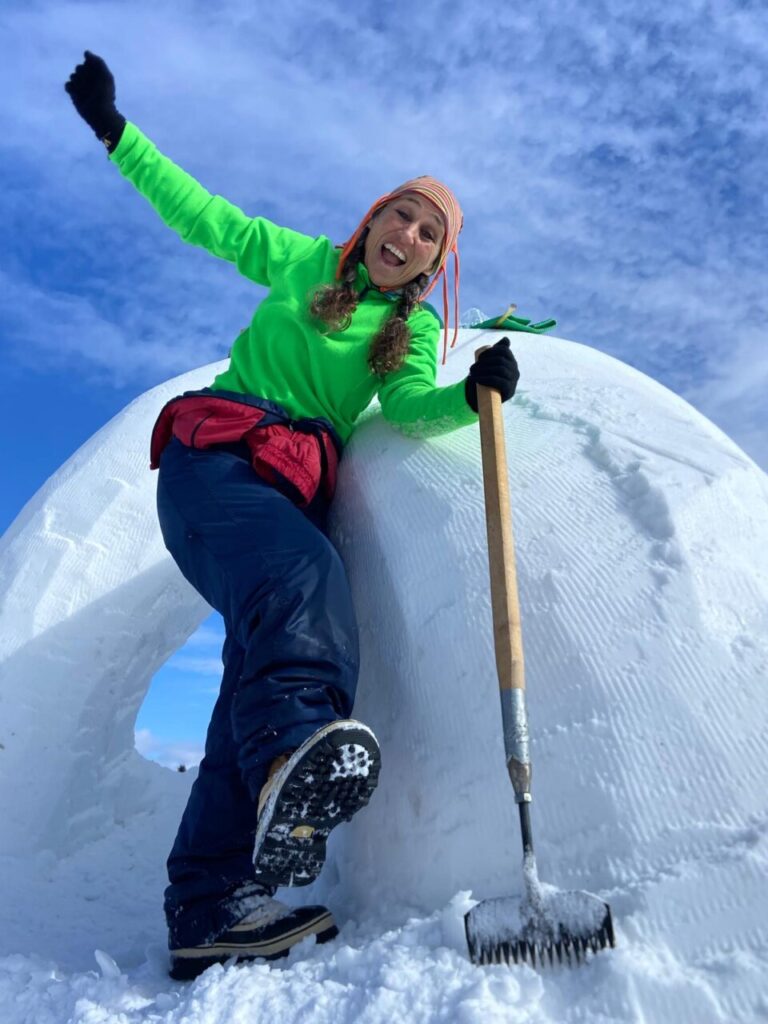 Esther Fuster sonríe mientras trabaja en una escultura de nieve.