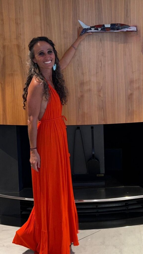 Esther Fuster señalando una obra de arte en su estudio.