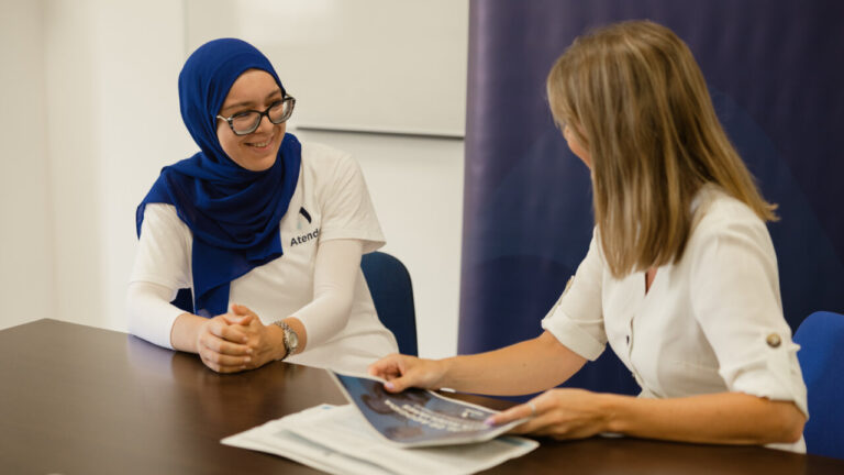 Dos mujeres conversando sobre empleo juvenil en una reunión.