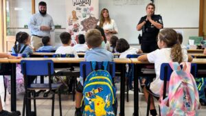 Clase de niños aprendiendo sobre Marratxí Cards con educadores y policía local.