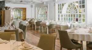 Interior del restaurante Los Rafaeles con mesas elegantes y ventanas luminosas