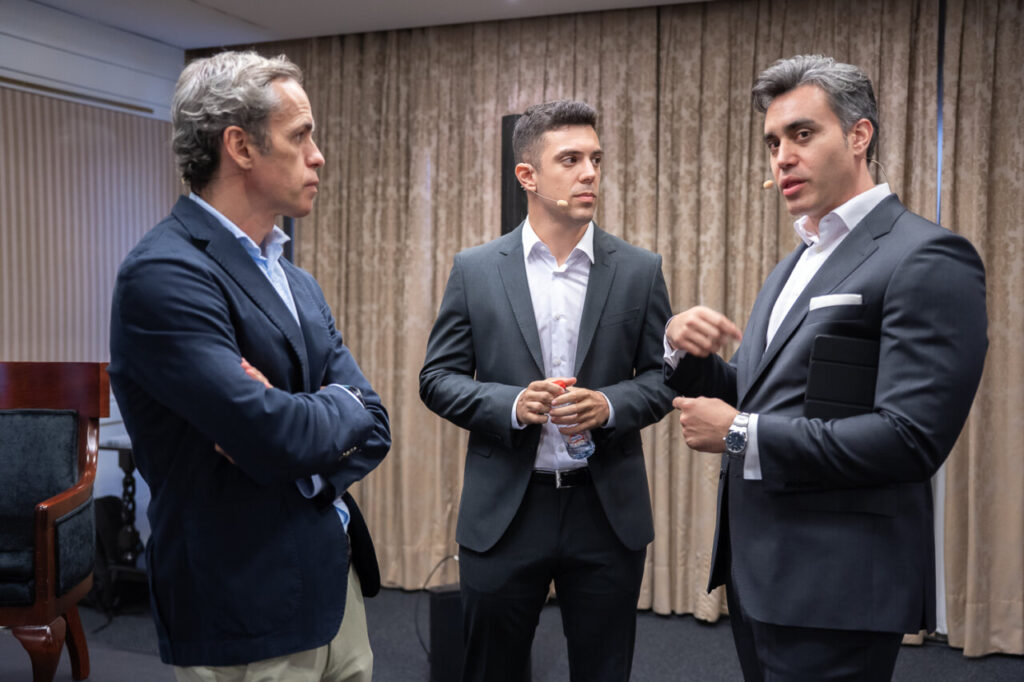 Tres hombres conversando en un evento de ciberseguridad