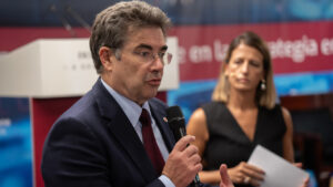 Persona hablando con micrófono en un evento de ciberseguridad.