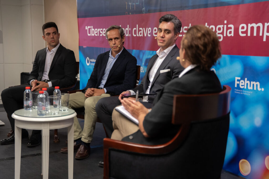 Panel de discusión sobre ciberseguridad con varios ponentes en un evento