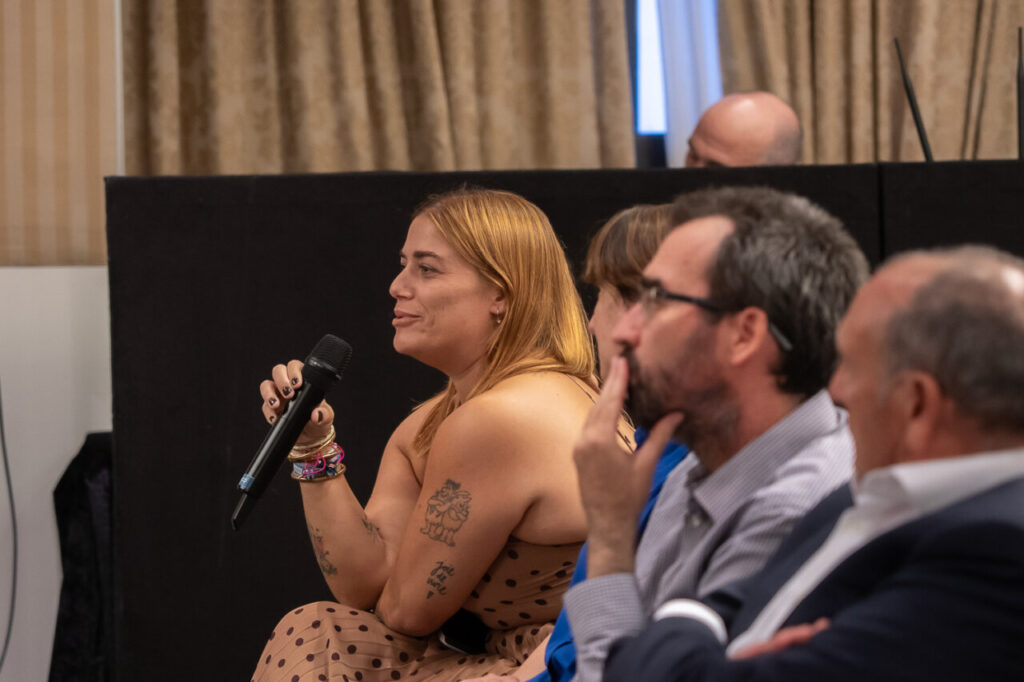 Participante en evento de ciberseguridad con micrófono en mano