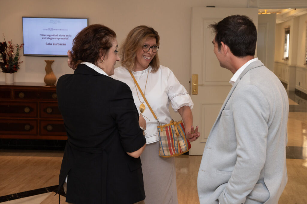 Tres personas conversando en un evento sobre ciberseguridad.