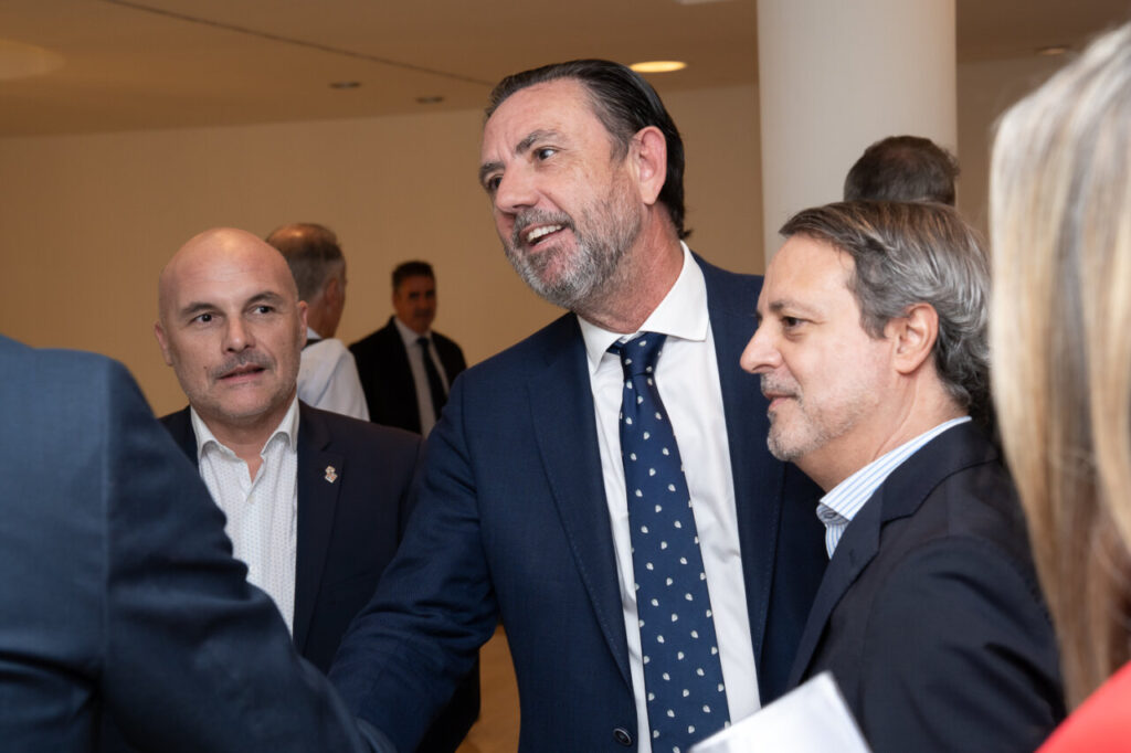 Tres hombres conversando en un evento de ciberseguridad