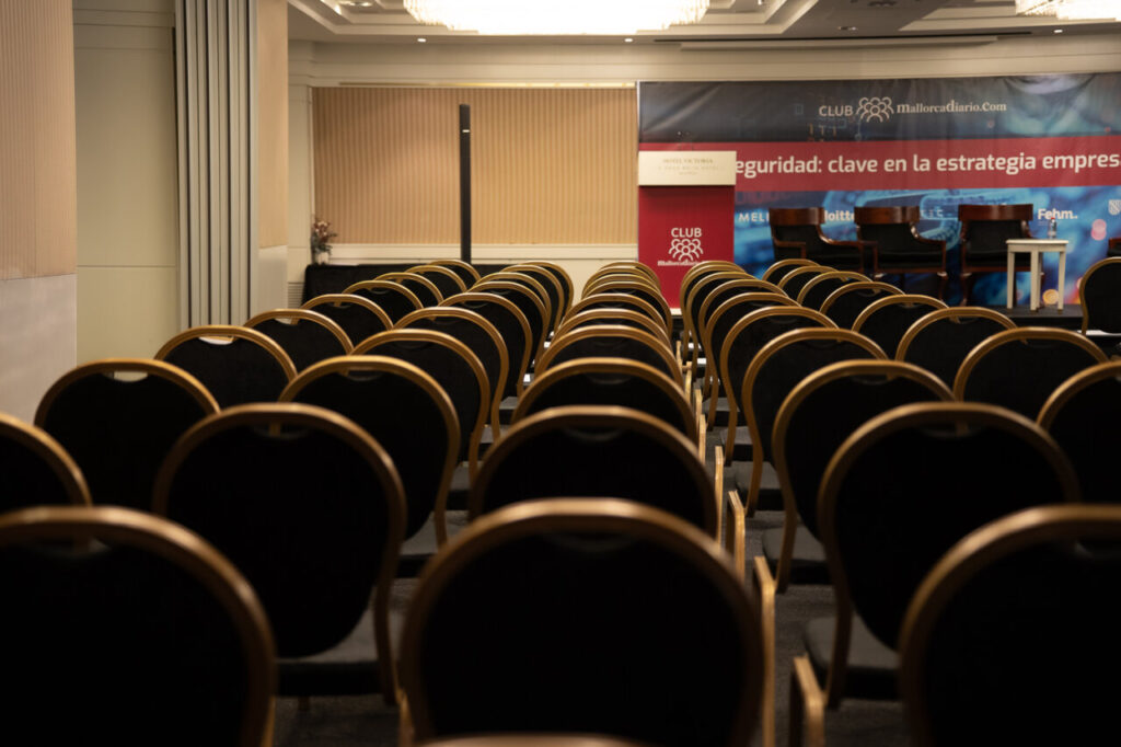 Sala de conferencias con asientos vacíos en un evento de ciberseguridad