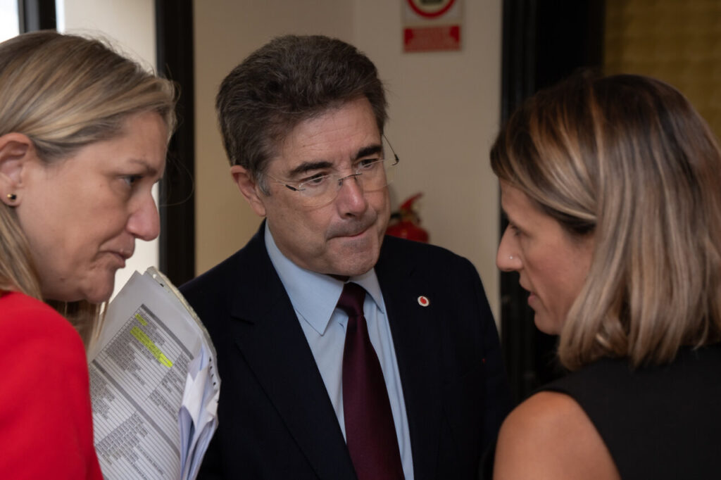 Tres personas conversando sobre ciberseguridad en un evento.