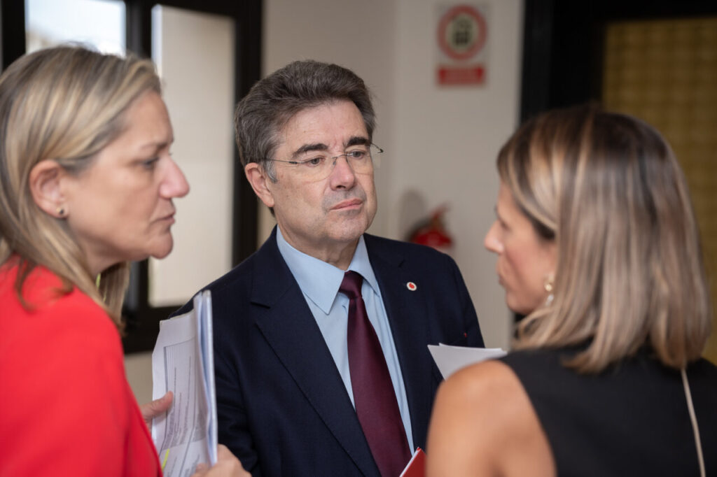 Tres personas conversando en un evento de ciberseguridad