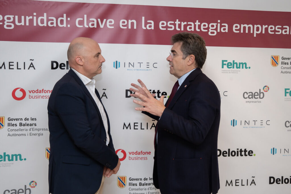 Dos hombres conversando sobre ciberseguridad en un evento empresarial