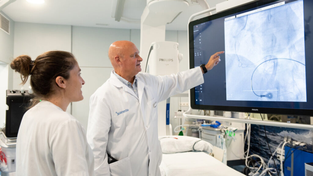 Médico y enfermera observando imágenes en pantalla durante un procedimiento médico