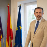 Alejandro Sáenz de San Pedro García en su oficina con banderas de España y Europa