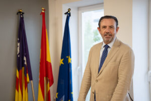 Alejandro Sáenz de San Pedro García en su oficina con banderas de España y Europa