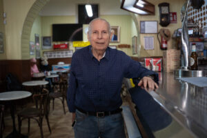 Mateu Martorell en el Bar España, sonriendo junto a la barra.