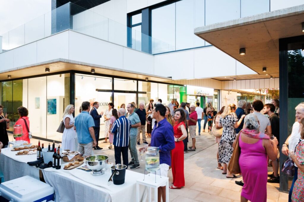 Evento de inauguraci&oacute;n de la exposici&oacute;n de Lucie Balaguer con asistentes conversando.