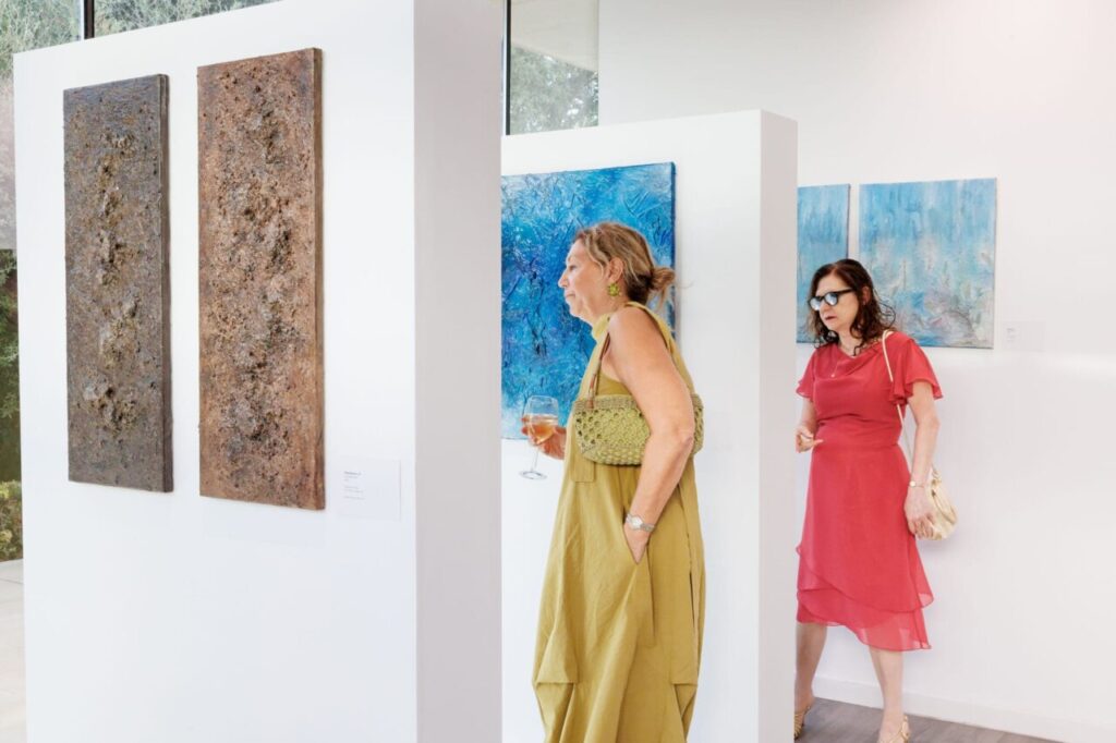 Visitantes observando obras de arte en una exposici&oacute;n de Lucie Balaguer.