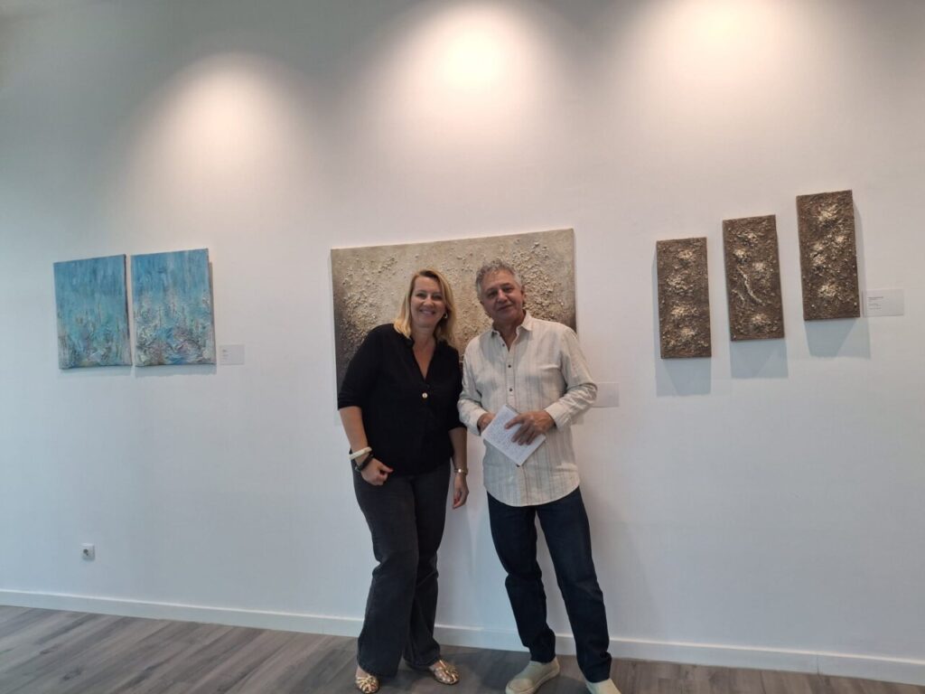 Dos personas posando en una galer&iacute;a de arte con obras de Lucie Balaguer.