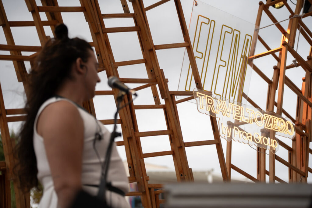 Mujer hablando en el Festival FLEM en Magaluf con un fondo de estructura de madera