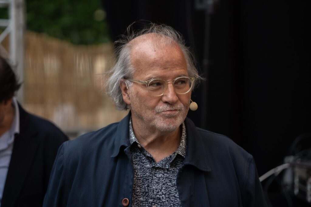 Persona en el festival FLEM con micrófono y mirada reflexiva