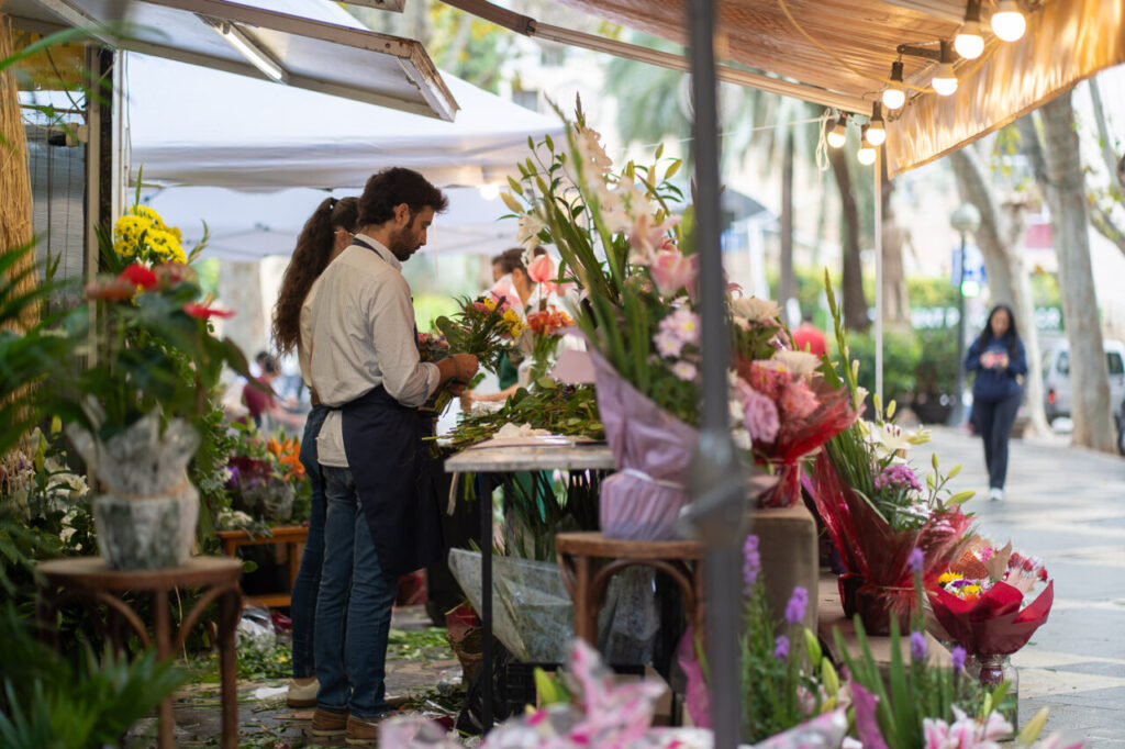 Florista preparando ramos de flores en un mercado al aire libre