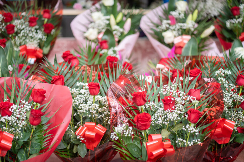 Ramos de flores con rosas rojas y decoraciones en un mercado
