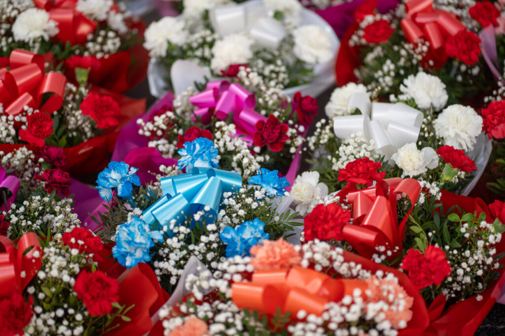Ramos de flores coloridas con cintas decorativas para el D&iacute;a de Todos los Santos