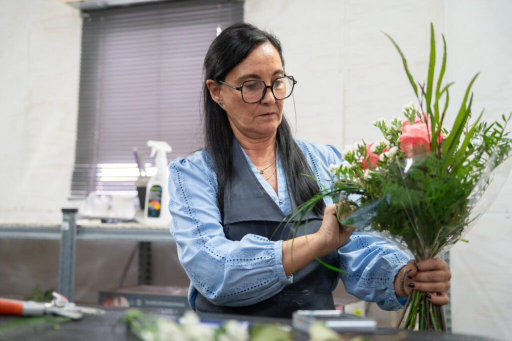 Mujer arreglando un ramo de flores en un taller de jardiner&iacute;a