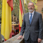 Gabriel Oliver Koppen posando junto a banderas en un edificio
