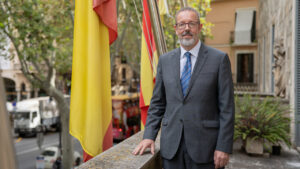 Gabriel Oliver Koppen posando junto a banderas en un edificio