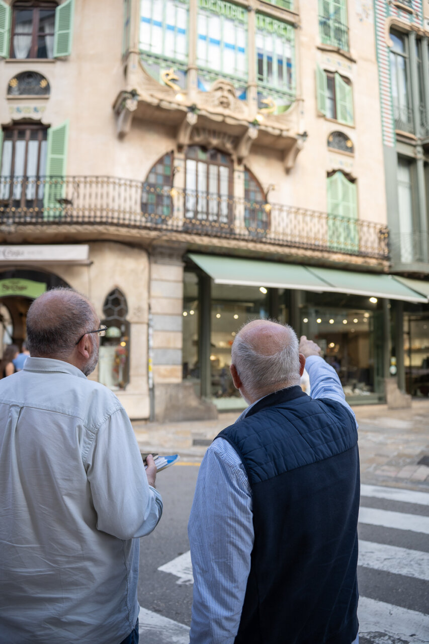 Dos hombres observando el Edificio Águila en un barrio de Mallorca.