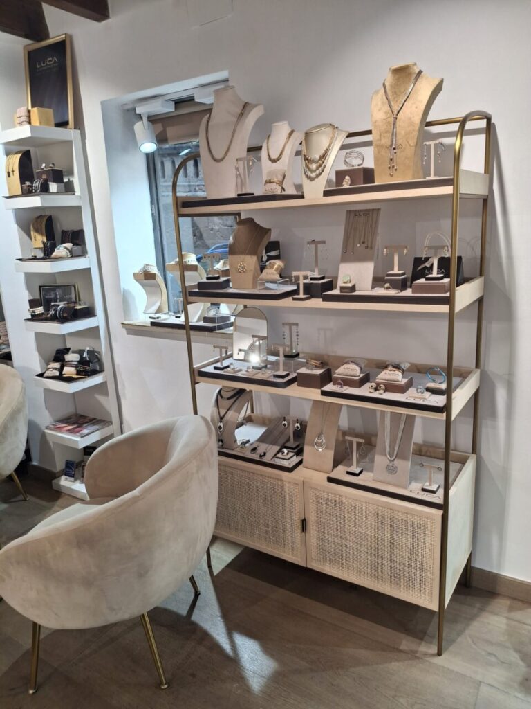 Exhibición de joyas de Luca Lorenzini en una tienda elegante.
