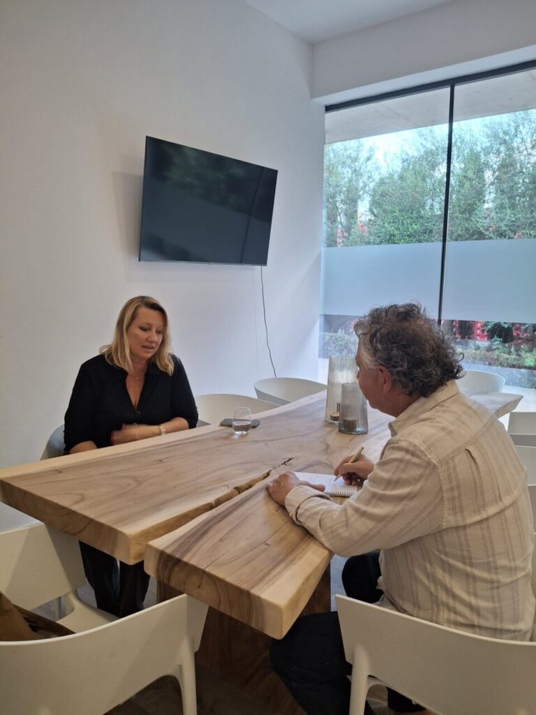 Lucie Balaguer respondiendo preguntas en una galer&iacute;a moderna.