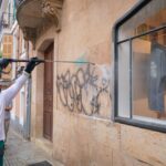 Trabajador de Emaya limpiando un grafiti de un edificio histórico en Palma.