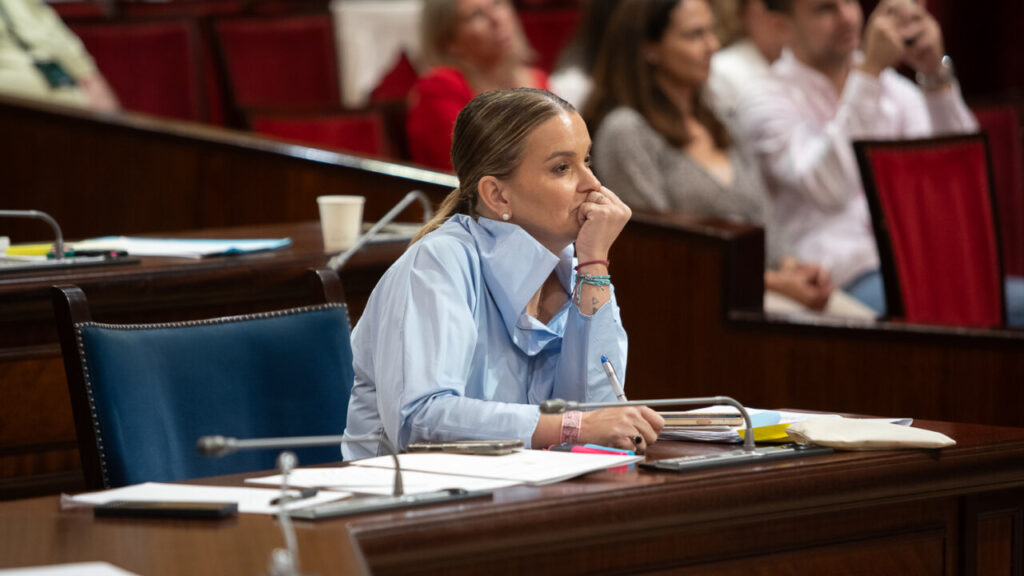 Mujer pensativa en el Parlamento durante un debate político.