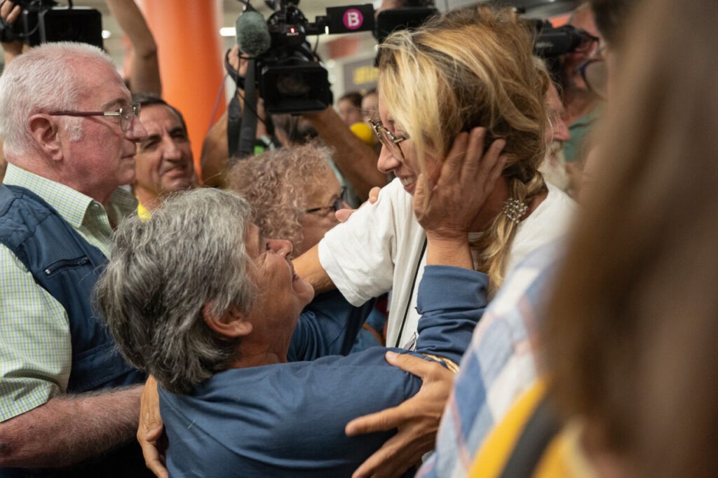 Reencuentro emotivo entre varias personas en un aeropuerto.