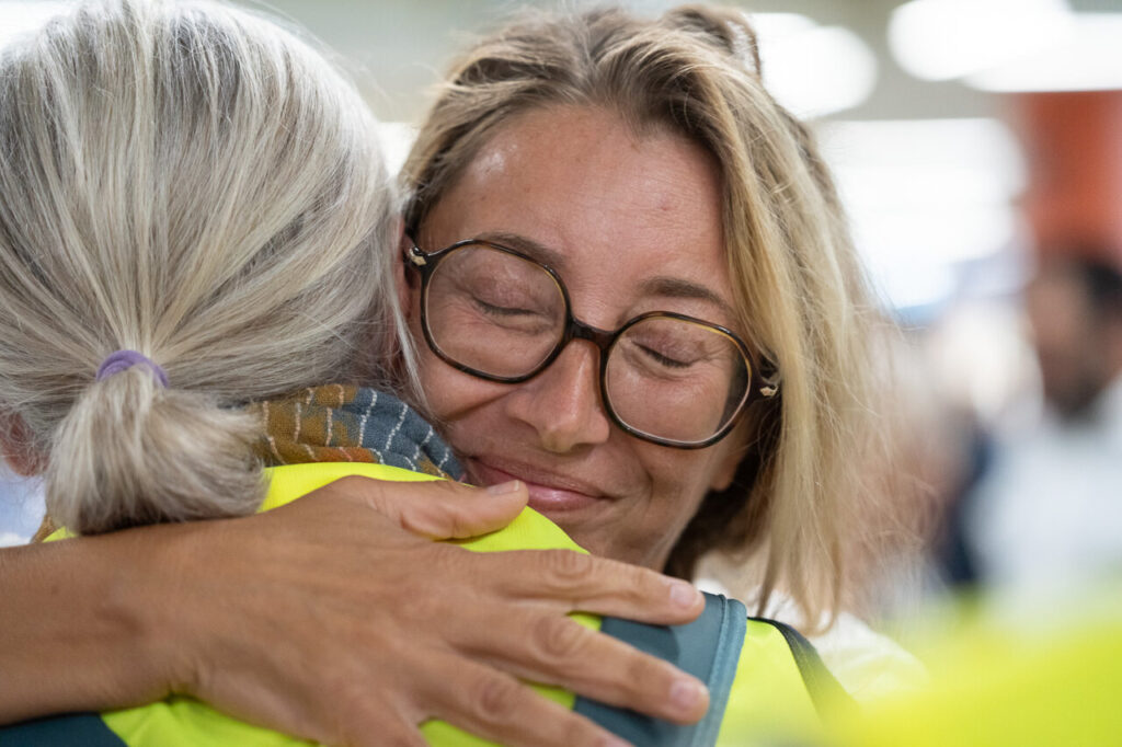 Mujeres abraz&aacute;ndose con sonrisas en un ambiente emotivo