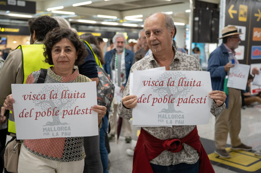 Dos personas sosteniendo carteles en un aeropuerto en Palma