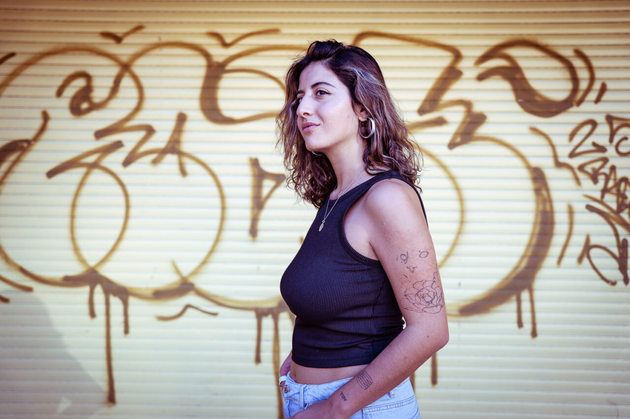 Selin Kaya posando frente a un fondo de graffiti
